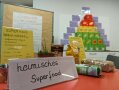 Lebensmittelpackungen auf einem Tisch, davor Schild mit Aufschrift "heimisches Superfood"