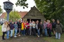 Teilnehmer und Veranstalter mit dem fertigen Brot vor dem Ofen