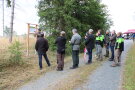 Personengruppe vor Erläuterungstafel im Wald