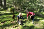 2 Jungs knien am Waldboden und schauen in die Kamera