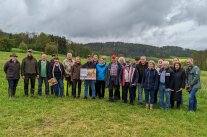 Personen stehen auf Wiese