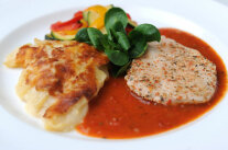 Teller mit Hähnchenschnitzel, Gemüse, Tomatensauce und Kartoffelgratin